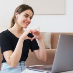woman making heart with hands while having video call
