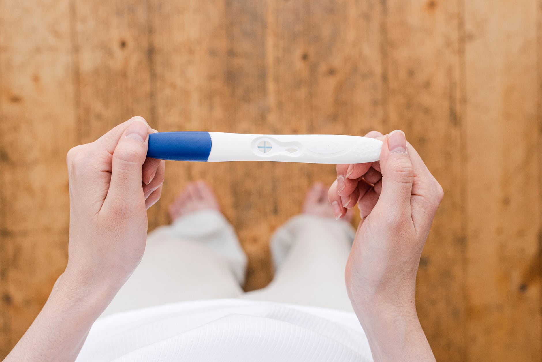 crop woman with pregnancy test - estou grávida e agora?