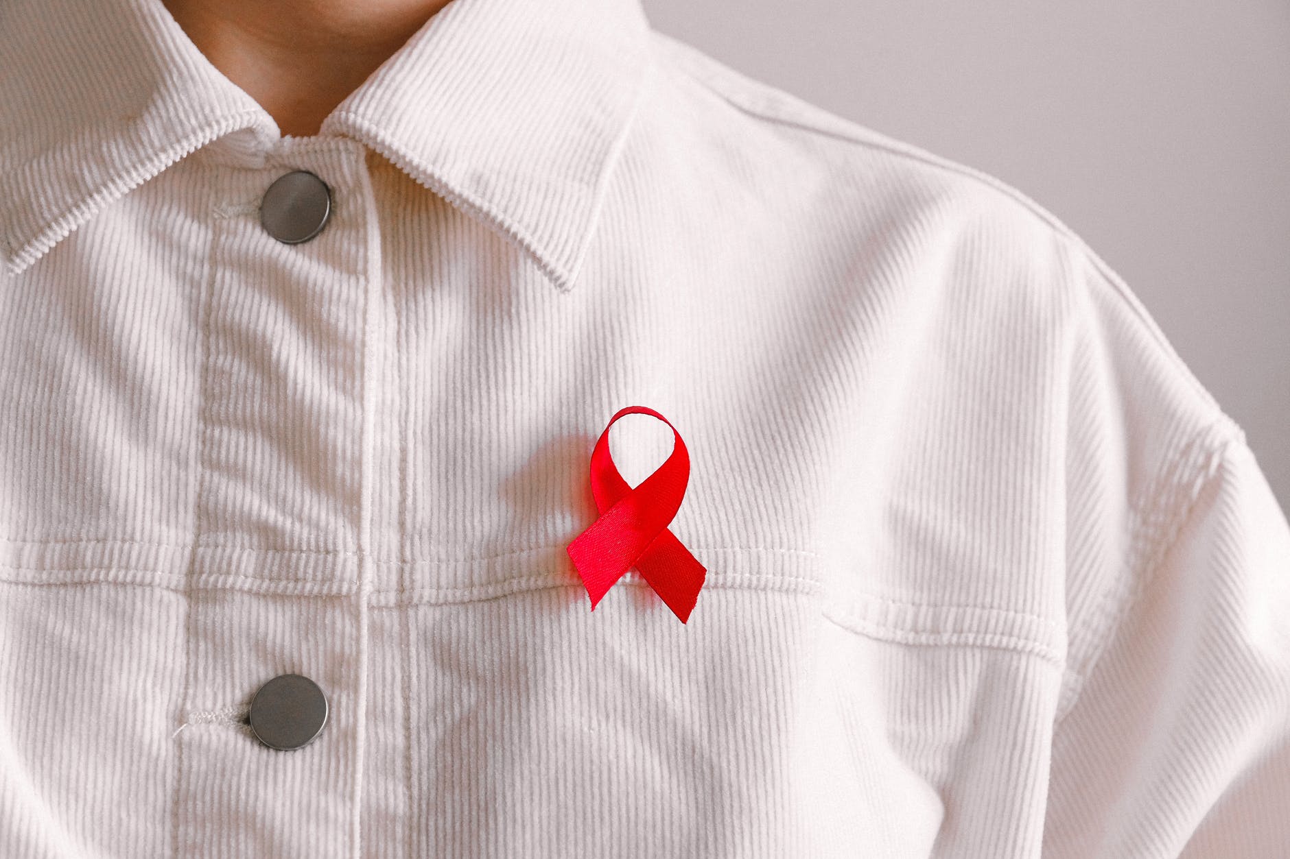 man wearing red ribbon HIV