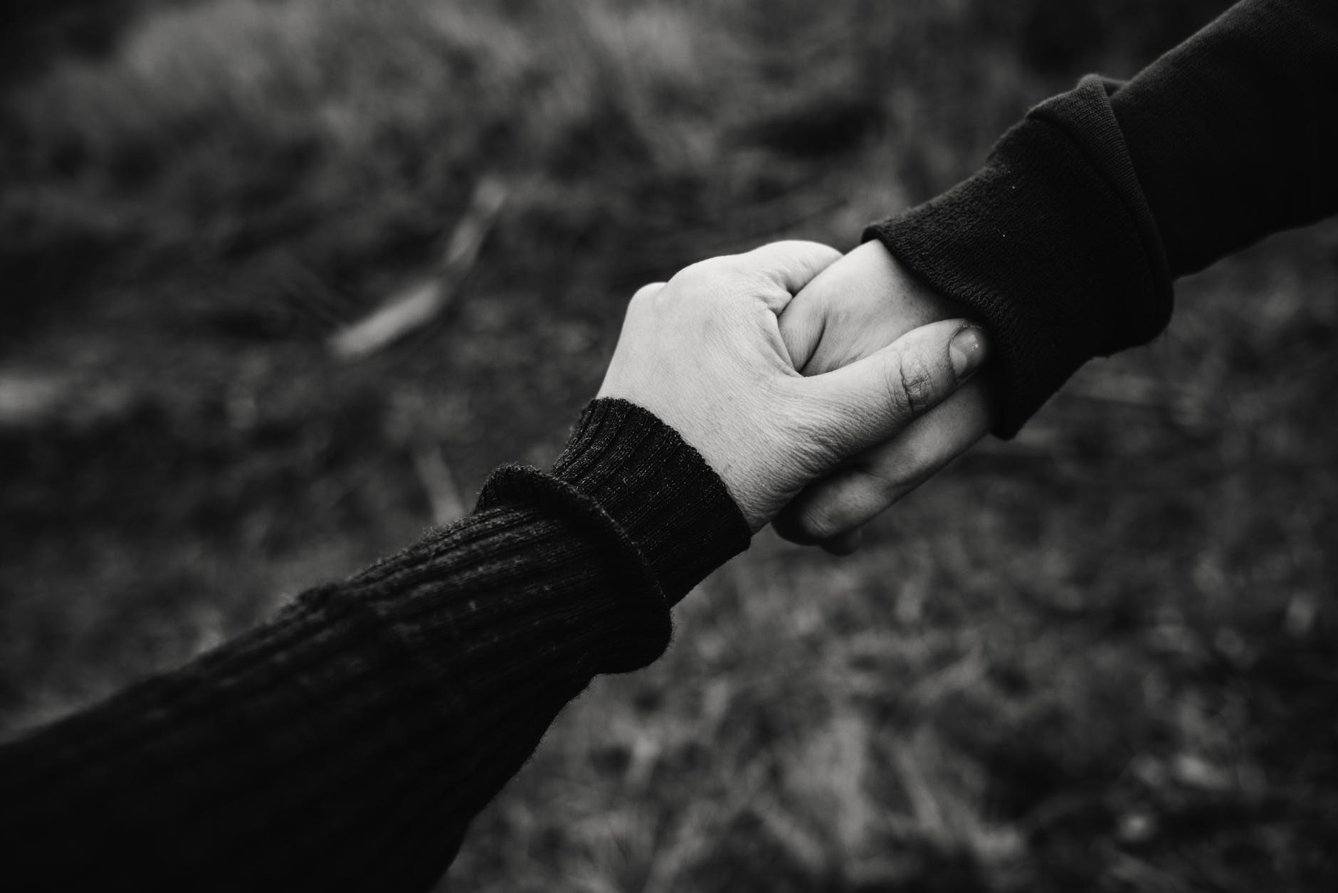black and white photo of holding hands incentivo dos amigos
