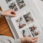unrecognizable person pasting photos in family album
