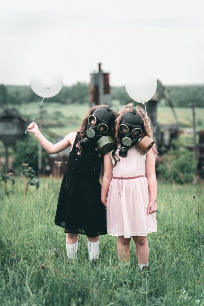 kids with gas mask holding a balloon filhos tóxicos
