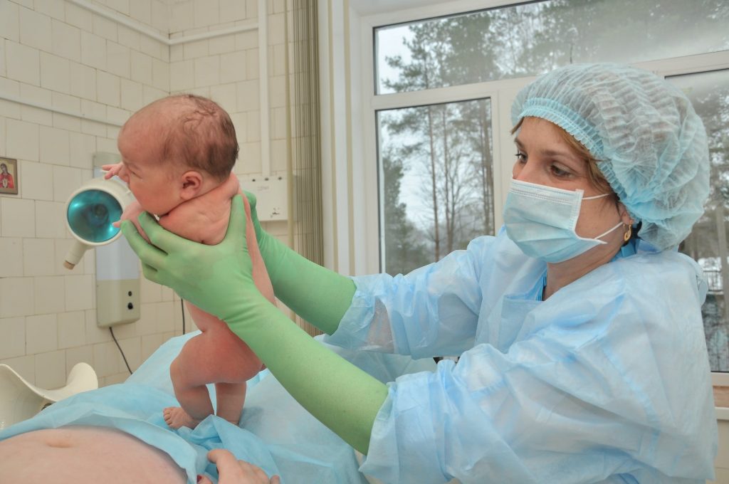 nurse holding a baby during birth