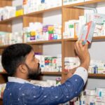 professional pharmacist in modern drugstore space for text
