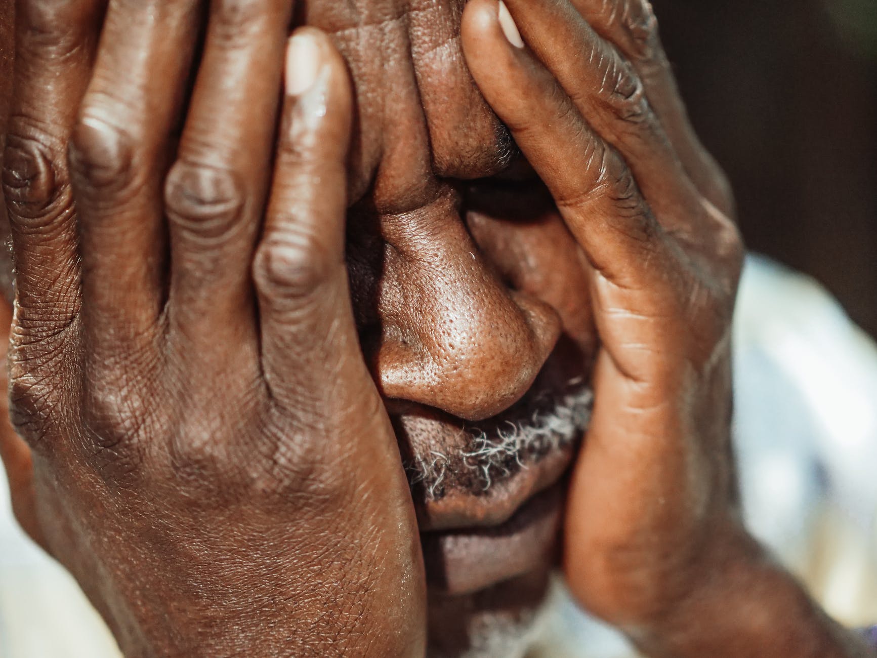 man in white shirt covering his face alzheimer
