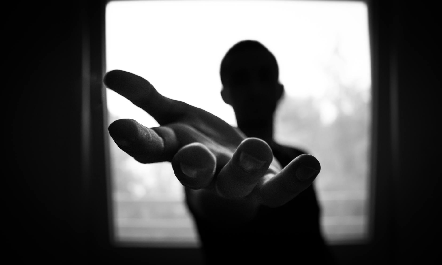 man s hand in shallow focus and grayscale photography - ajuda ou socorro?