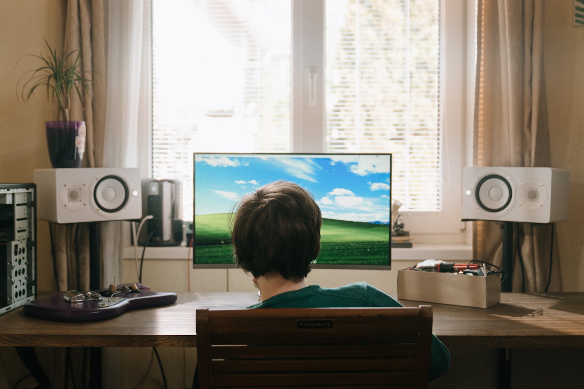 boy in red shirt sitting on chair in front of black flat screen tv