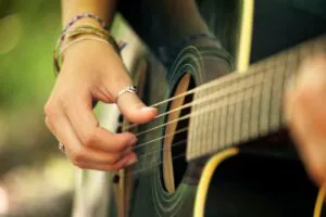 meus pais querem que eu faça faculdade, pessoa tocando violão, faculdade, violão, instrumento musical